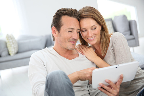 Couple qui compare en ligne sur une tablette